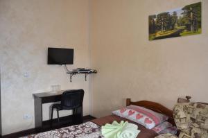 a bedroom with a bed and a television at Brama Ruska in Kamianets-Podilskyi