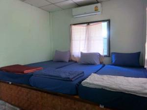 two beds in a room with a window at แพแหม่มทัวร์ in Sai Yok