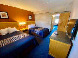 een hotelkamer met 2 bedden en een aanrecht bij Breeze Inn & Suites, Virginia Beach in Virginia Beach