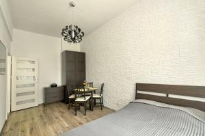 a bedroom with a bed and a table with chairs at Apartament w centrum :) in Krakow