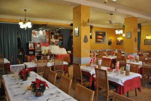 een eetkamer met witte tafels en stoelen met rode accenten bij Albergo Motel Dosdè in Grosio