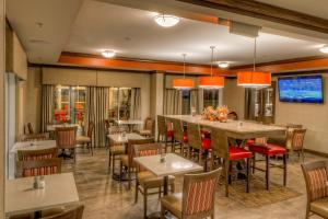 a restaurant with a bar and tables and chairs at La Quinta by Wyndham Pigeon Forge in Pigeon Forge