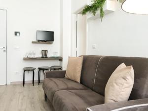 a living room with a brown couch and stools at VIATOREM Suites in Torre dell'Orso
