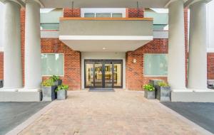 a brick building with columns and a door at Holiday Inn Express Hotel & Suites Foley, an IHG Hotel in Foley