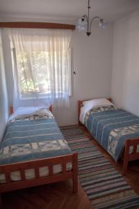 two beds in a room with a window at Apartment Curri in Pučišća