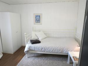 Eifel-Moezelhuis في Bergweiler: غرفة نوم بسرير ابيض وعليها كيس اسود