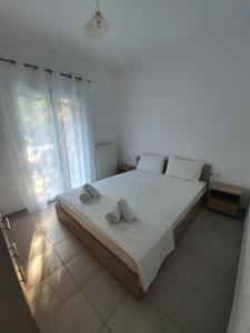 a bedroom with a large bed with two towels on it at Eleana's apartments in Gouvia