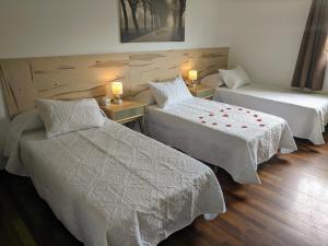 a hotel room with two beds and two tables at Dalt Vila Salou Deluxe in Salou