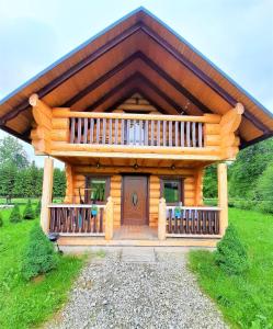 een grote houten hut met een groot terras bij Chatki Góralskie in Rabka