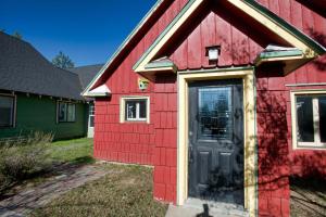a red house with a door on the side of it at Cottage Inn by Casago McCall - Donerightmanagement in McCall