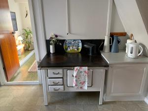 a small kitchen with a counter top and a table at Cosy old house Vágar next to Mykines in Sørvágur