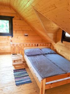 Bett in einem Holzzimmer in einer Hütte in der Unterkunft Chatki Góralskie in Rabka-Zdrój