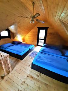two beds in a room with a ceiling at Chatki Góralskie in Rabka