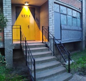 斯摩棱斯克的住宿－SERA LOFT，大楼一侧的黄色门,有楼梯