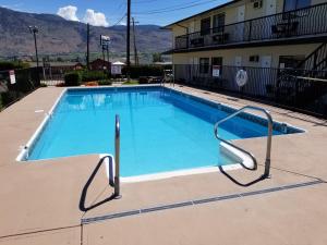 a large blue swimming pool in front of a building at Lakeview Motel & Suites in Osoyoos
