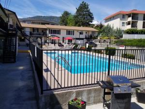 a swimming pool with a fence next to a building at Lakeview Motel & Suites in Osoyoos