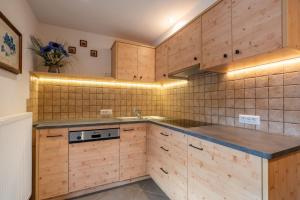 a kitchen with wooden cabinets and a sink at Ragerhof in Versciaco di Sopra