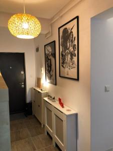 a bathroom with a sink and pictures on the wall at Sunset apartment in Bistriţa