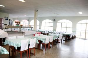 a dining room with green and white tables and chairs at Hotel e Restaurante Champagne in Campo Belo