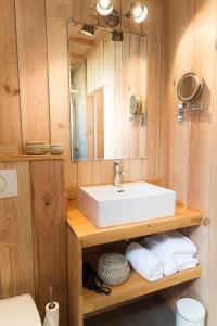 a bathroom with a sink and a mirror and towels at Centre Cap-ferret, les chambres du phare, bassin in Cap-Ferret