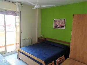 a bedroom with a blue bed in a green wall at Hotel Eliseo in Giardini Naxos