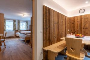 Zimmer mit Holzwänden und einer Küche mit einem Tisch in der Unterkunft Ragerhof in Obervierschach