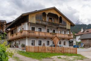 ein großes Holzhaus mit einem Zaun davor in der Unterkunft Ragerhof in Obervierschach
