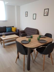 a table in a living room with chairs and a couch at Appart' O bernai in Obernai