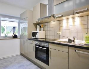 uma cozinha com electrodomésticos em aço inoxidável e um micro-ondas em friends & family Domizil Willingen em Willingen