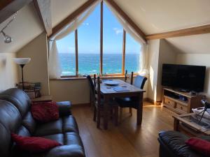 a living room with a table and a view of the ocean at Beautiful Wales in Barmouth