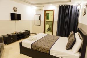 a bedroom with a bed and a television in a room at Esquire Hotels & Apartments in Rawalpindi