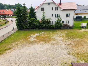 an empty yard in front of a white house at Limba in Łeba