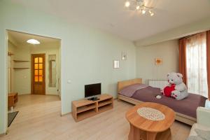 a teddy bear sitting on a bed in a room at Apartments on Kuznechnaya 79 in Yekaterinburg