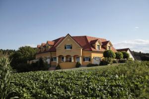 a house in the middle of a field of crops at Ferienhof Uhudler-Arkaden in Stegersbach