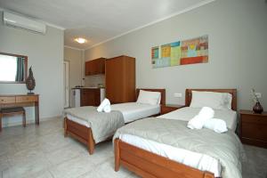 a bedroom with two beds and a table and a desk at Panorama Siviris in Siviri