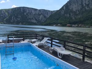 a swimming pool on the deck of a boat on a lake at Casa Panoramic in Dubova