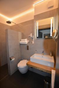 ein Badezimmer mit einem Waschbecken, einem WC und einem Spiegel in der Unterkunft GS DiePension in Griesheim