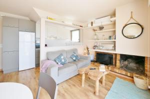 a living room with a couch and a fireplace at Casa Concha Apartamentos - WeHost Costa Brava in Calella de Palafrugell +155 photos