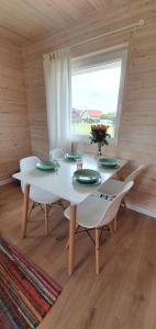 a dining room with a table and chairs and a window at Baltic Beach House in Rewal