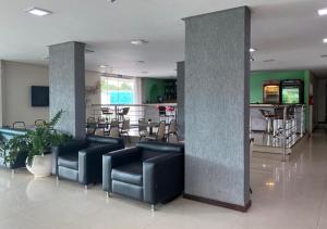 a lobby with couches and chairs in a building at Biss Inn Hotel in Goiânia