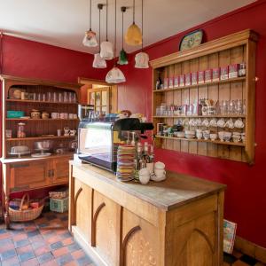 a kitchen with red walls and a counter with dishes at Victoria House in Church Stretton