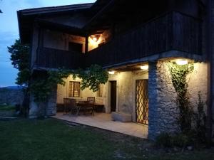 un patio fuera de una casa por la noche en Karst Stone Cottage, en Štanjel