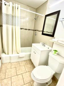 a bathroom with a toilet and a sink and a shower at Budget Inn in Roswell