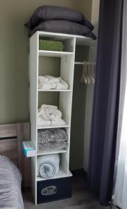 a white shelf with towels in a bedroom at Lilafee in De Panne