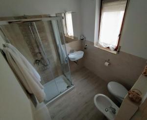 uma casa de banho com um chuveiro, um WC e um lavatório. em B&B Alghero Mare Chiaro em Alghero