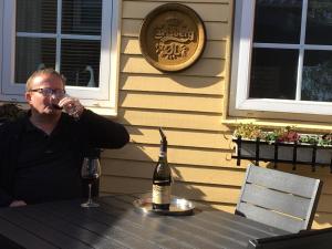 Ein Mann, der mit einem Glas Wein am Tisch sitzt. in der Unterkunft Bed and Breakfast Nustrup in Vojens