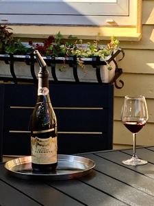 una bottiglia di vino seduta su un tavolo accanto a un bicchiere di Bed and Breakfast Nustrup a Vojens