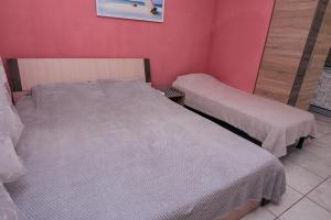 um quarto com 2 camas e uma parede rosa em Guest house VadLen em Odessa