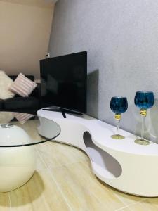 - un salon avec une télévision et 2 verres à vin dans l'établissement Noblesse Hause, à Gammertingen