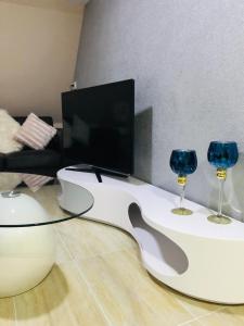 ein Wohnzimmer mit einem TV und 2 Weingläsern in der Unterkunft Noblesse Hause in Gammertingen